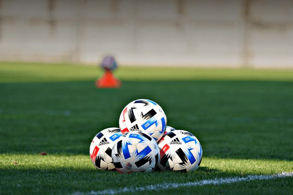 A pile of footballs at a training session.